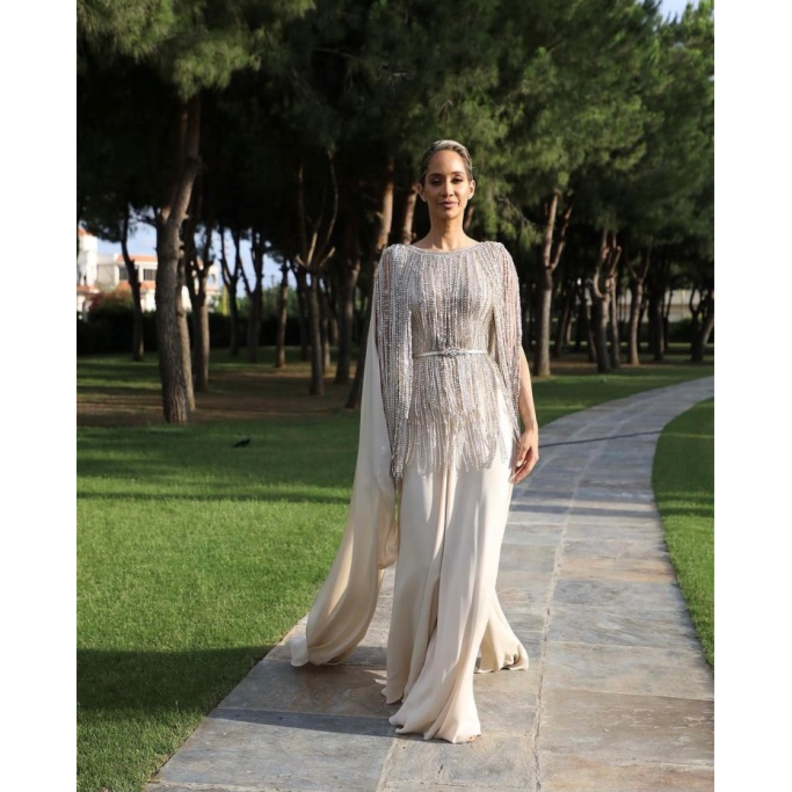 جامبسوت باللون العاجي مرفق بكاب طويل ومزيّن بالشراشيب المرصّعة باللؤلؤ