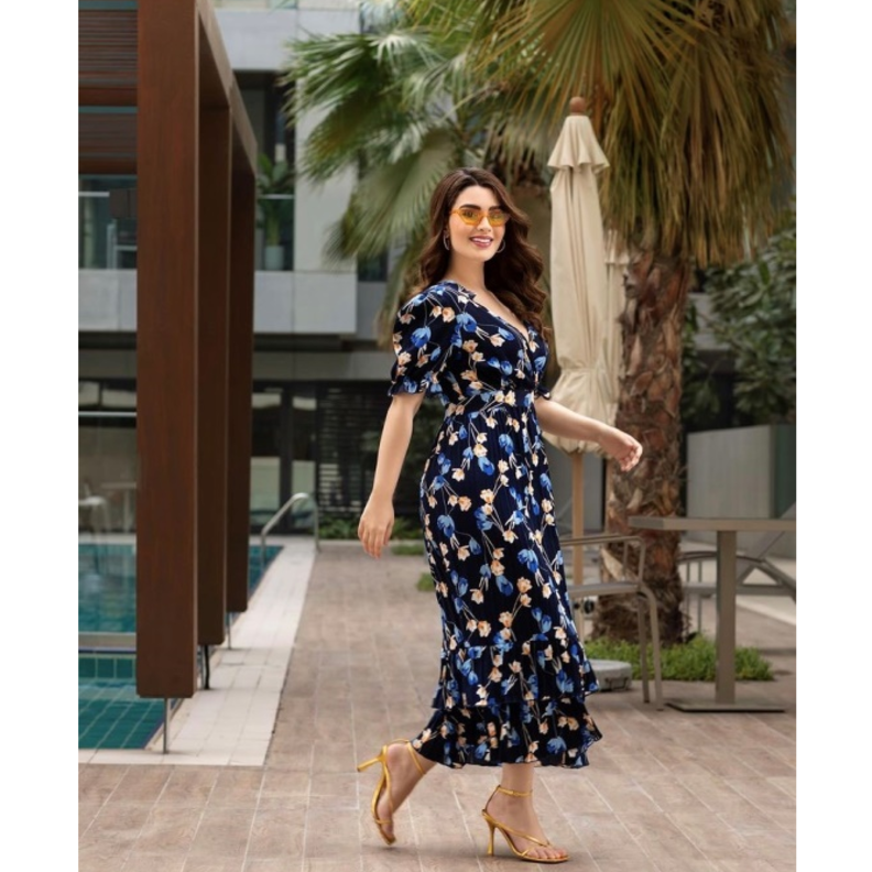 الفستان الأسود الذي تميّز بأكمام القصيرة المنفوخة ومزيّن بنقشة الورود باللونين الأزرق والبيج ونسّقت معه الصندل الأصفر