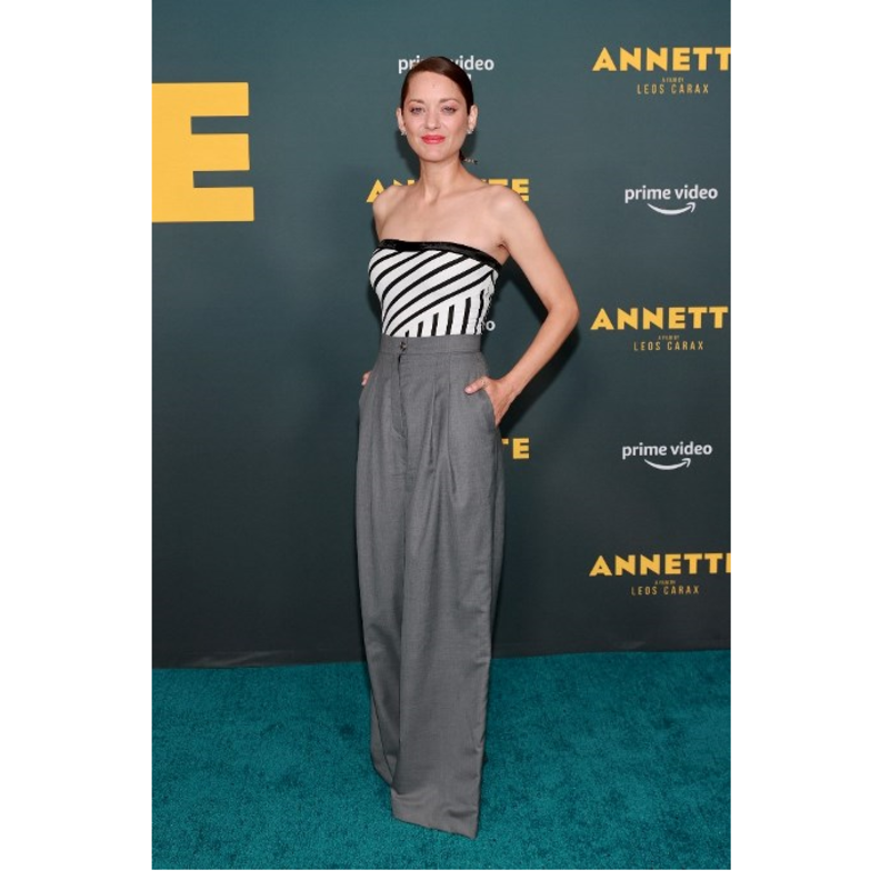 ماريون كوتيارد بإطلالة من دار CHANEL تألفت من البنطلون الرمادي الواسع والتوب بنقشة التقليمات