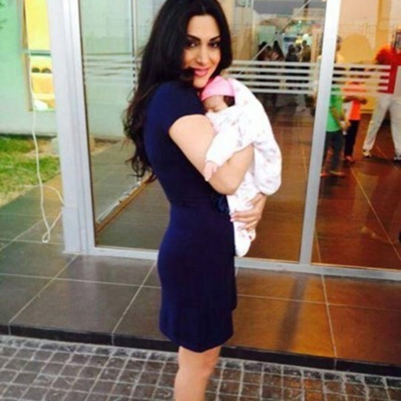 مايا نصري تحمل طفلها