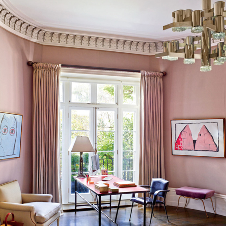 الجدران في زاوية الغرفة باللون الزهري حيث تبدو فيه الستائر جزءا منهم