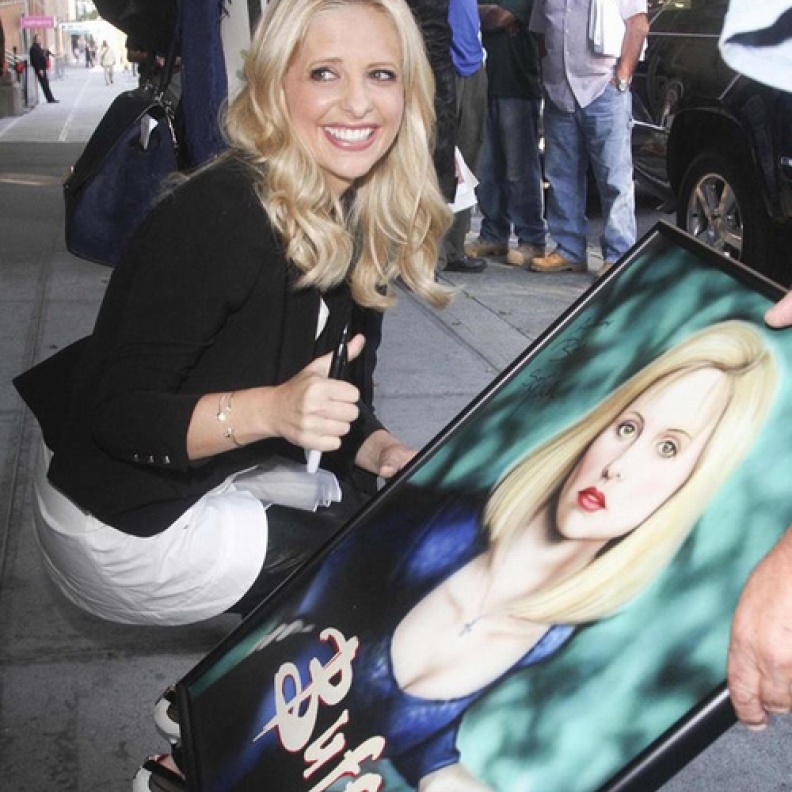 سارة ميشيل غيلير توقع على صورة لها رسمها أحد معجبيها تحمل شخصيتها في مسلسلها الشهير buffy the vampire slayer في نيويورك الاثنين