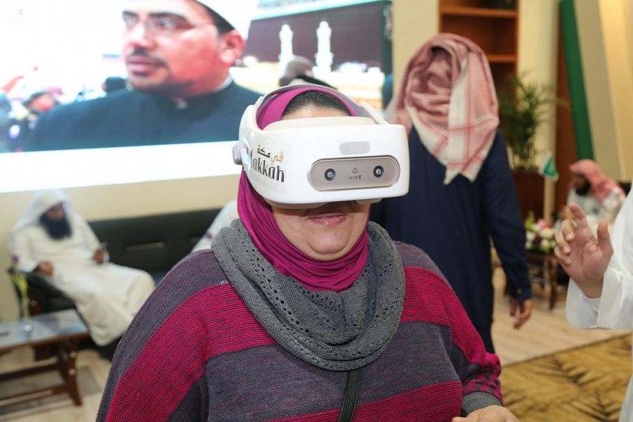 إحدى الزائرت لجناح السعودية أثناء تجربة الواقع الإفتراضي لزيارة الحرمين الشريفين