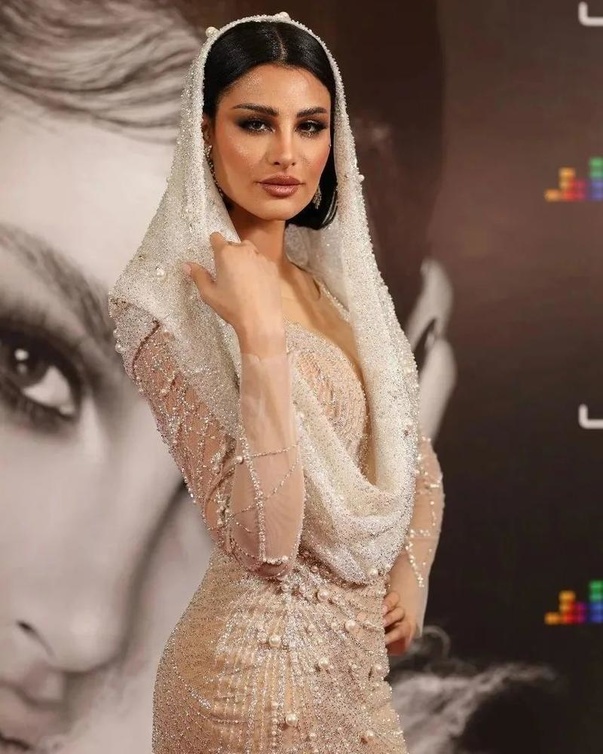 اميمة طالب بفستان ابيض وغطاء للرأس 