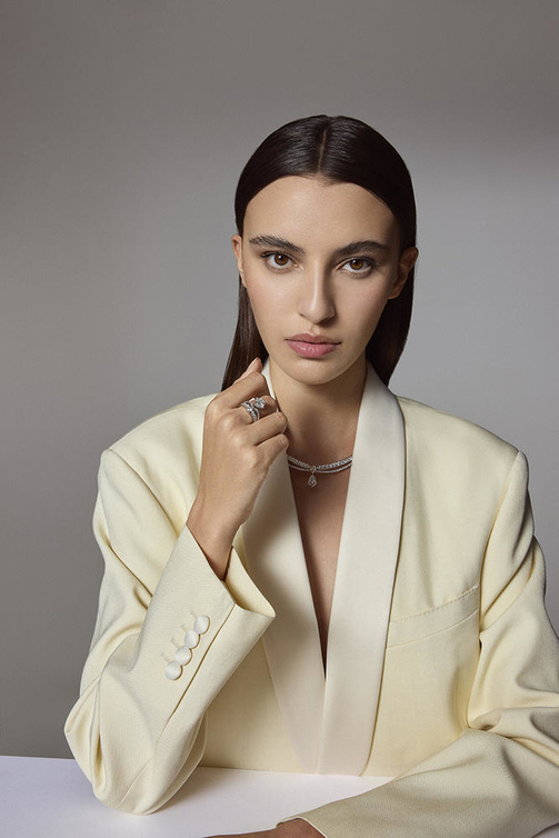 من "شوميه"Chaumet ، عقد "جوزفين إكلا فلورال" Joséphine "Eclat Floral" من البلاتين المرصع بالماسات الدائرية المتألقة، وبماسة إجاصية عيارها نحو 0.70 قيراط، وماسة وسادية القطع عيارها نحو قيراطين؛ وخاتم "جوزفين إكلا فلورال" Joséphine "Eclat Floral" من البلاتين المرصع بماسات، منها ماسة وسادية درجة نقاوتها FVVS1 وعيارها 3.08 قيراط.  سترة "تكسيدو" بقصة ضخمة ولون أبيض سكري من "سيلين"Celine .
